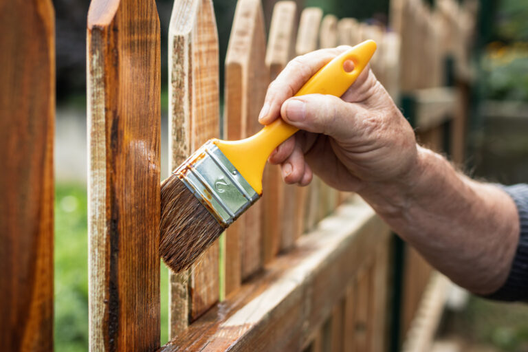 paintingprotectivevarnishonwoodenpicketfenceatbackyardman top interior exterior painters victoria bc van isle paint